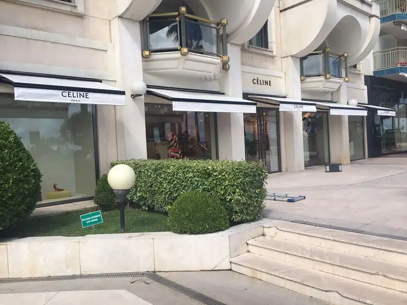 Boutiques Celine à Cannes : vitrines abritées par des stores blancs, lambrequins blancs bordés de noir