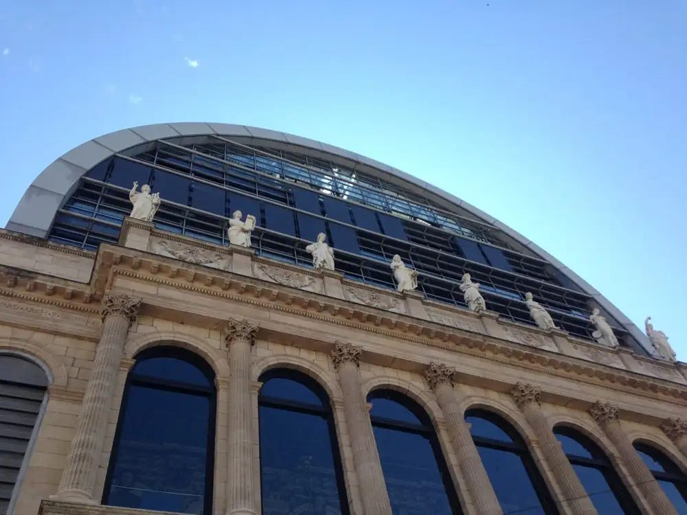 Façade de l’Opéra de Lyon : colonnes, statues et, au-dessus, la façade vitrée en demi-cercle