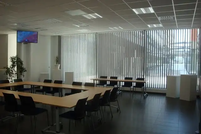 Salle de réunion aux baies vitrées équipées de stores à lames verticales, aux bureaux du Progrès