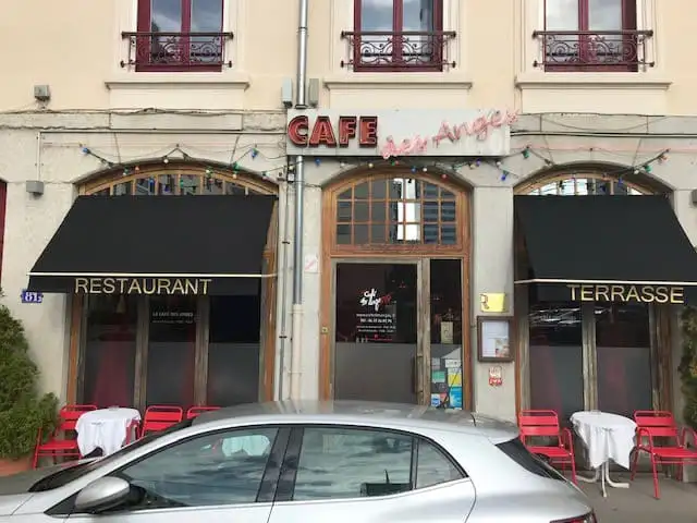 Façade d’un café-restaurant : deux bannettes noires neuves, lettrées « Restaurant » et « Terrasse »