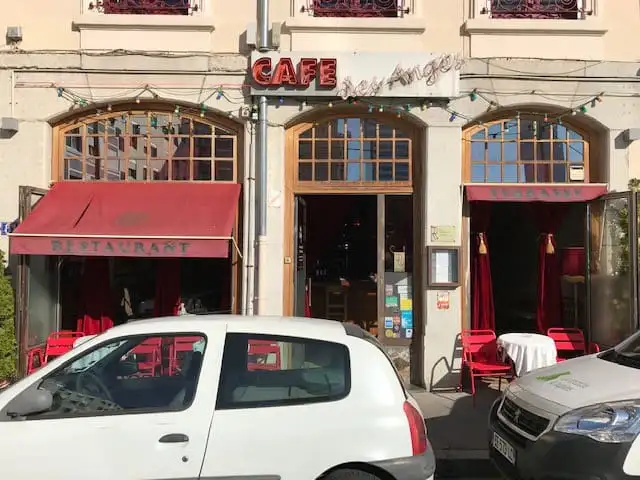 Façade d’un café-restaurant avant le rentoilage, sous ses anciennes bannettes rouges