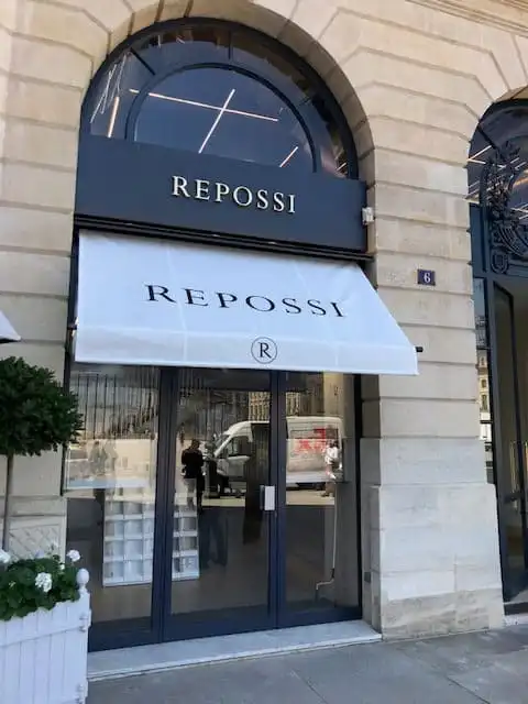 Bannette blanche au nom de Repossi, lettrage imprimé, sur la vitrine de la place Vendôme