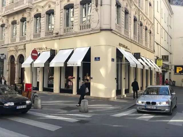 La boutique Rituals à l’angle d’un carrefour, vitrines abritées par des bannettes blanches à lettrage