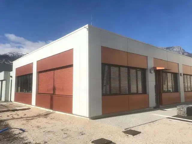 Bâtiment de plain-pied, brise-soleil couleur cuivre intégrés aux panneaux de façade