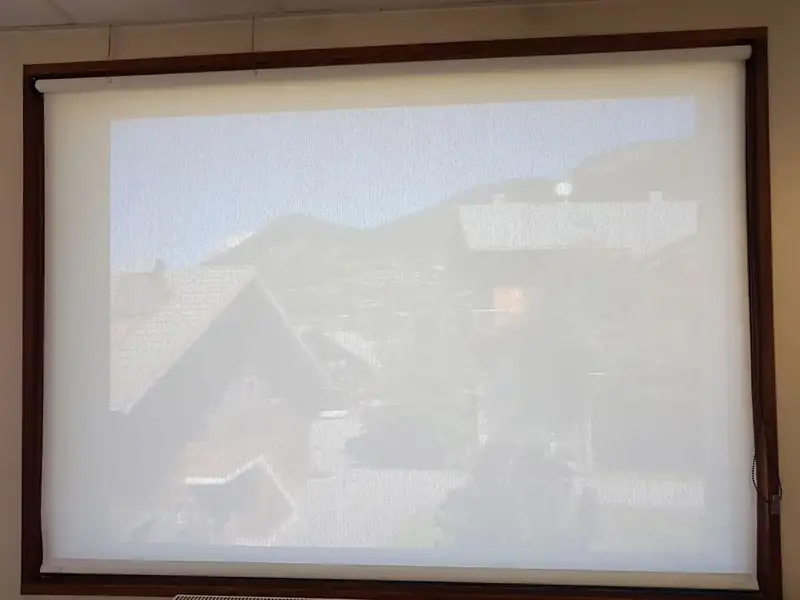 Le store baissé : à travers la toile screen, les chalets et la montagne restent visibles