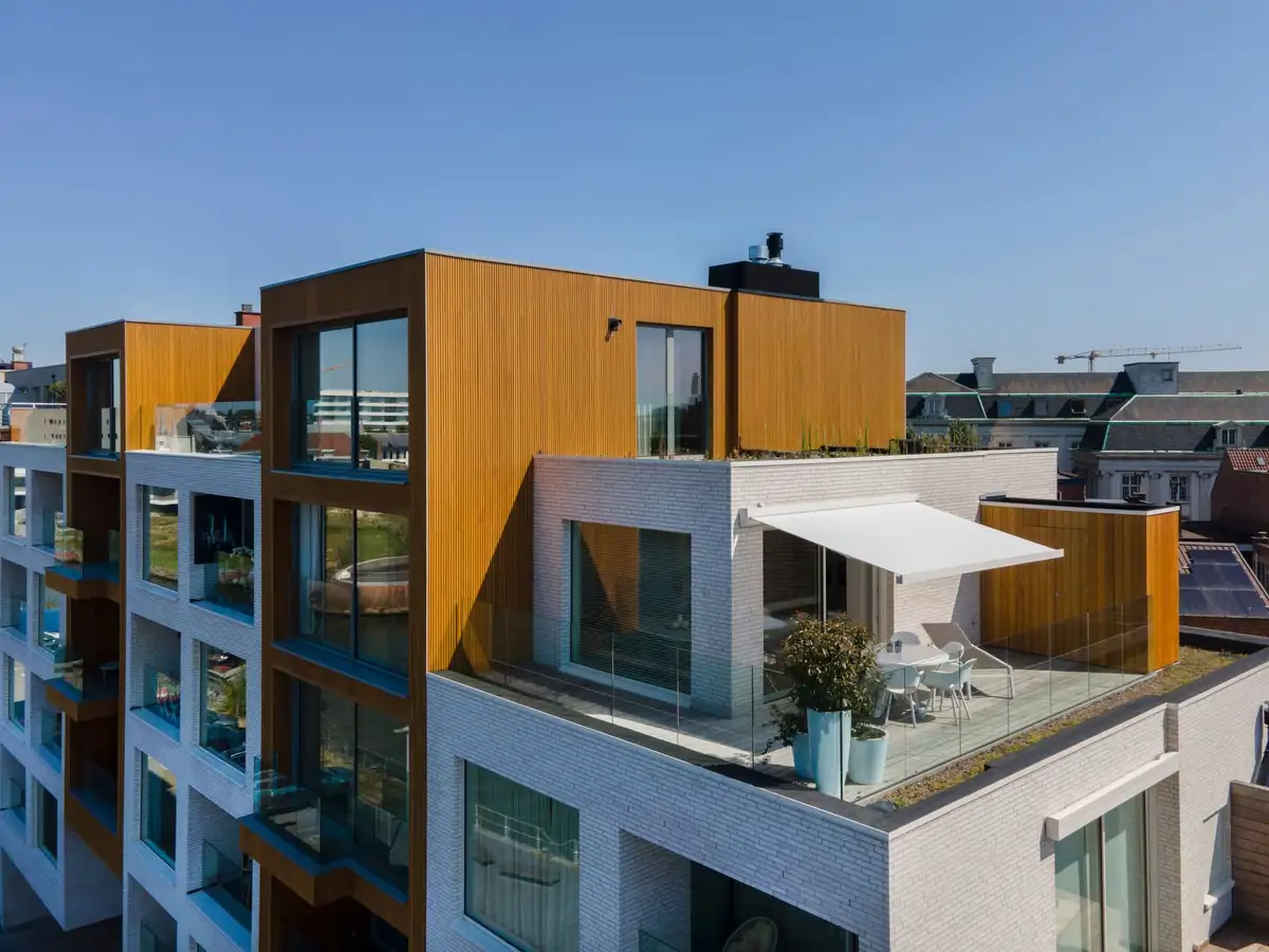 Store banne blanc déployé sur le toit-terrasse d’un immeuble contemporain