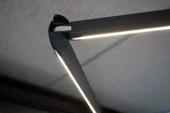 Bras articulé d’un store banne avec éclairage LED intégré, sous la toile