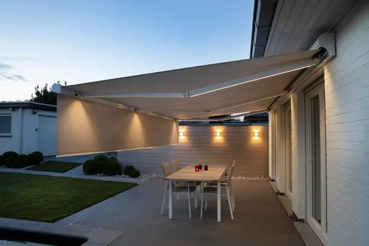 Store banne blanc déployé le soir, éclairé par des LED intégrées sous le coffre