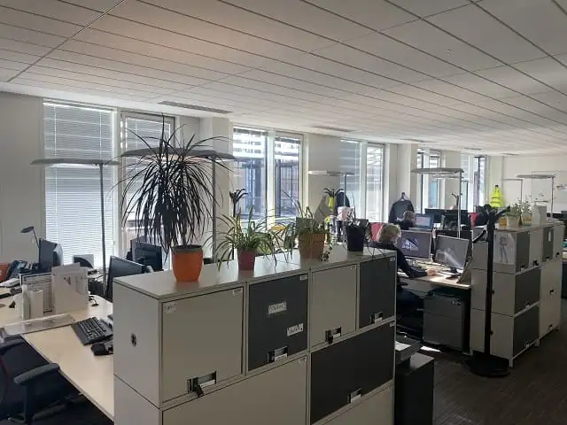 Plateau de bureaux ouvert du siège d’APICIL, stores vénitiens aux fenêtres