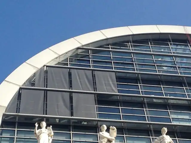 Stores enrouleurs extérieurs baissés sur la façade vitrée de l’Opéra de Lyon, au-dessus des statues