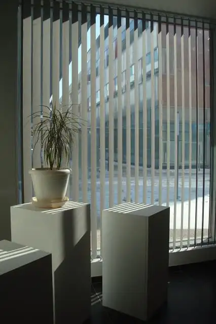 Stores à lames verticales orientées devant une baie vitrée, aux bureaux du Progrès