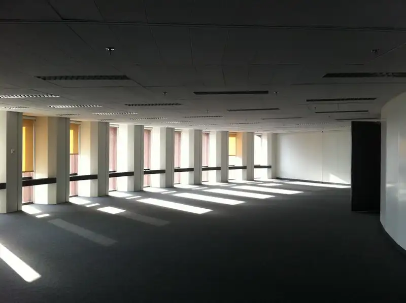 Plateau de bureaux de la tour, le long de ses fenêtres étroites, quelques stores enrouleurs baissés